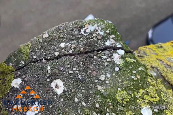Beschadigde en verweerde nokvorst met scheuren en mos in Heesch Beschadigde en verweerde nokvorst met scheuren en mos in Heesch
