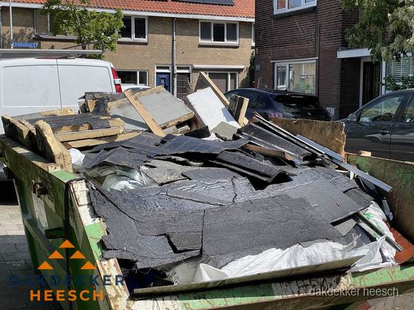Afvalcontainer met gesloopt dakmateriaal tijdens dakkapel renovatie in Heesch