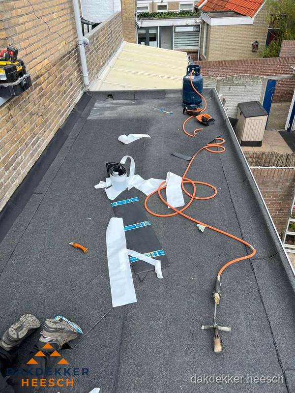 Dakdekkers bezig met bitumen dakbedekking in Heesch
