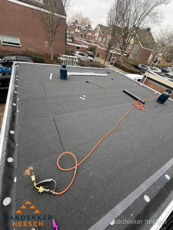 Afgewerkte dakrenovatie met bitumen op plat dak in Heesch
